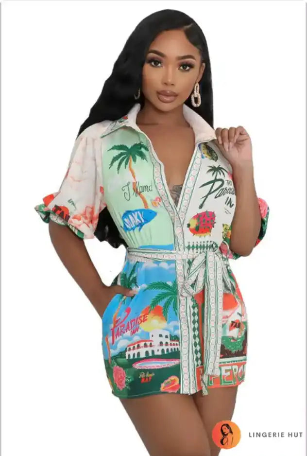 Tropical print romper with palm trees, beach scenes and floral designs in vibrant colors.