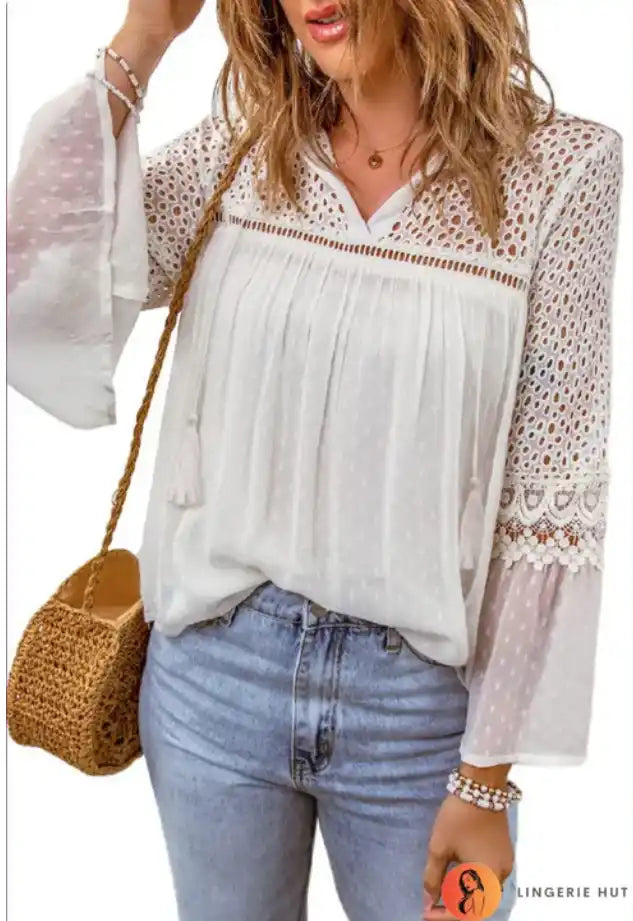 White lace-detailed peasant blouse with flowy sleeves paired with blue jeans.